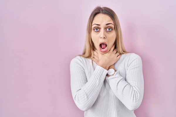 Young Blonde Woman Wearing White Sweater Pink Background Shouting Suffocate — Stock Photo, Image
