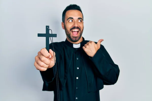 英俊而惊慌的牧师 留着胡子 手握天主教十字大拇指 微笑着 张开嘴 — 图库照片