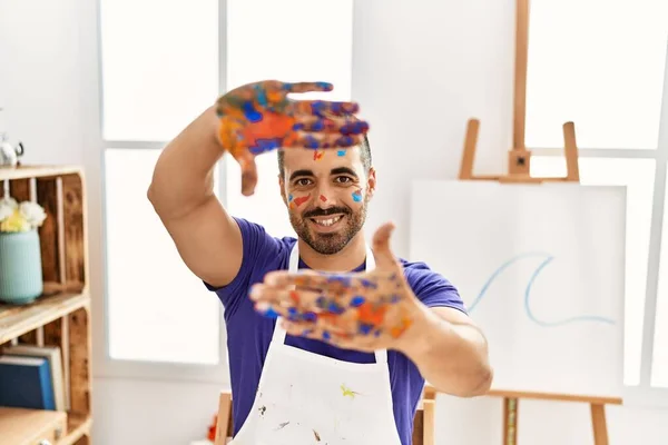 Młody Hiszpan Uśmiecha Się Pewnie Pokazując Pomalowane Dłonie Pracowni Artystycznej — Zdjęcie stockowe