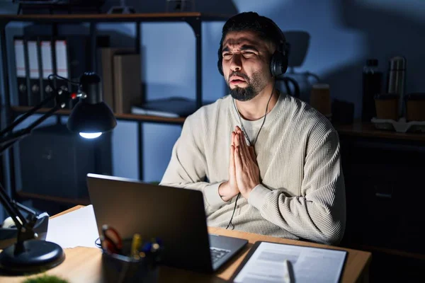 Genç Yakışıklı Adam Geceleri Bilgisayar Kullanarak Çalışıyor Elleriyle Yalvarıyor Dua — Stok fotoğraf