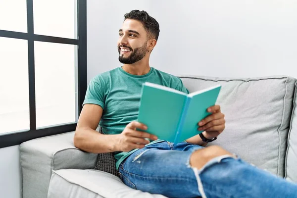 Jeune Homme Arabe Lecture Livre Couché Sur Canapé Maison — Photo