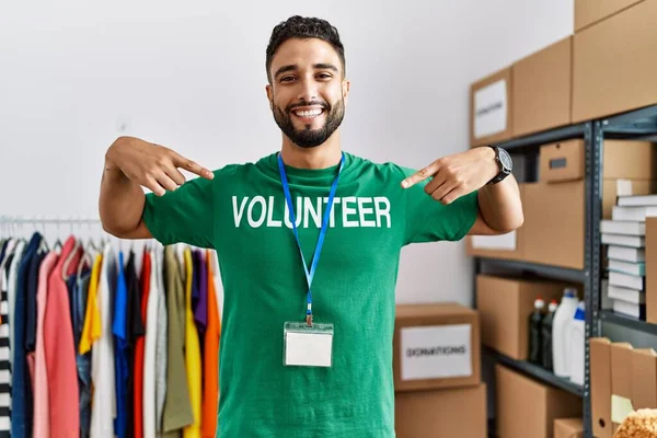Jonge Arabier Man Wijzend Met Vingers Naar Vrijwilliger Uniform Liefdadigheidscentrum — Stockfoto