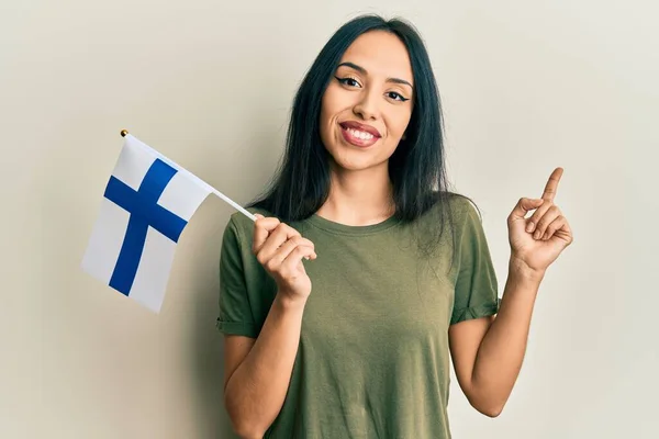 Jovem Hispânica Segurando Bandeira Finlândia Sorrindo Feliz Apontando Com Mão — Fotografia de Stock
