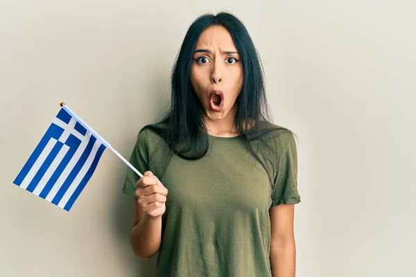 Młoda Latynoska Dziewczyna Trzyma Grecką Flagę Przestraszony Zdumiony Otwartymi Ustami — Zdjęcie stockowe