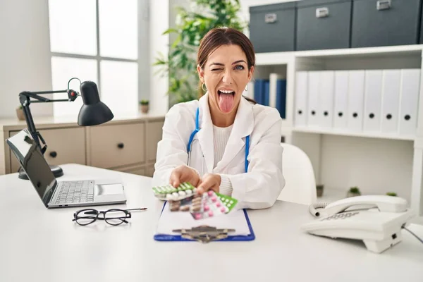 Junge Brünette Ärztin Mit Tabletten Die Zunge Herausstreckt Glücklich Mit — Stockfoto