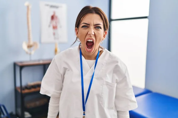 Young Brunette Woman Working Pain Recovery Clinic Angry Mad Screaming — Stock Photo, Image