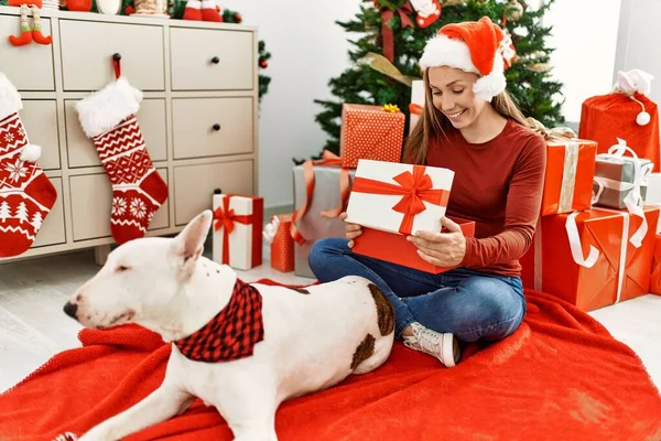 Young Caucasian Woman Unboxing Gift Sitting Dog Christmas Tree Home — 스톡 사진