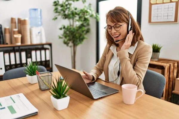 Ofiste çalışırken gülümseyen Kafkasyalı bir çağrı merkezi ajanı..