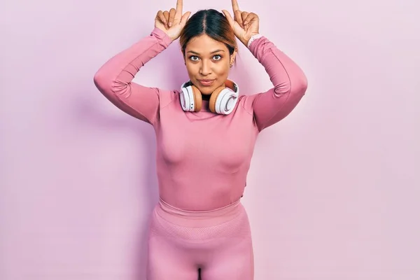 Beautiful Hispanic Woman Wearing Gym Clothes Using Headphones Doing Funny — стоковое фото
