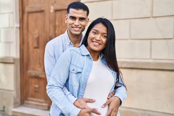 Young Latin Couple Expecting Baby Hugging Each Other Standing Street — Stockfoto