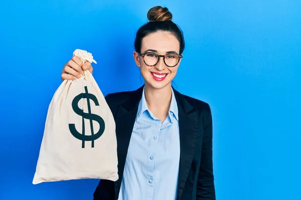 Young Hispanic Girl Wearing Business Clothes Holding Dollars Bag Looking — Stok fotoğraf