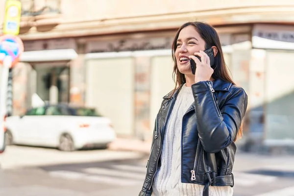 若い女性が自信を持って路上でスマートフォンで話して笑っている — ストック写真