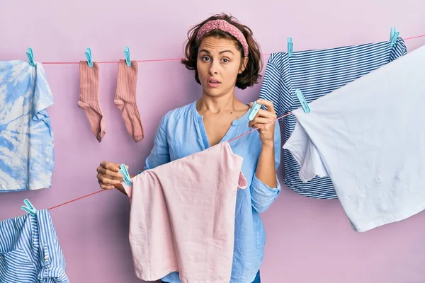 Genç esmer kadın çamaşırlarını yıkarken şok olmuş yüzüne cımbız tutuyor. Şüpheci ve alaycı bakıyor. 