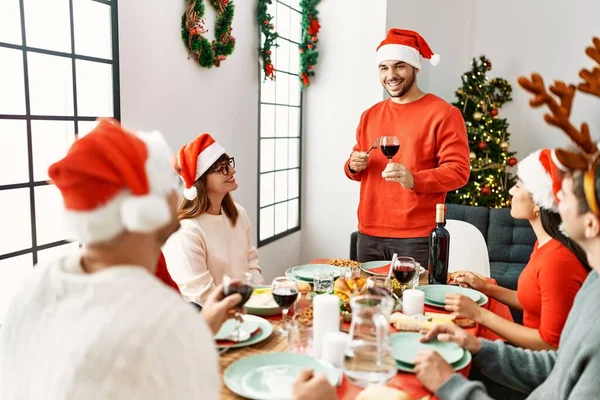 クリスマスディナーを食べながら家でトーストを話す若者のグループ — ストック写真