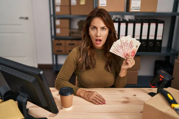 Hispanic Woman Working Small Business Ecommerce Holding Shekels Scared Amazed — Stock Photo, Image