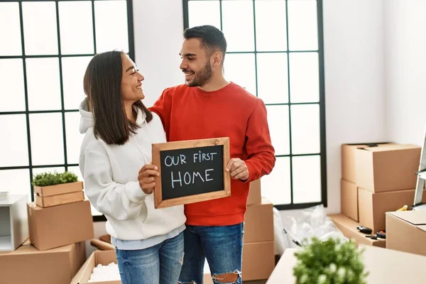 Young Latin Couple Smiling Happy Holding Blackboard Our First Home — Stock Photo, Image