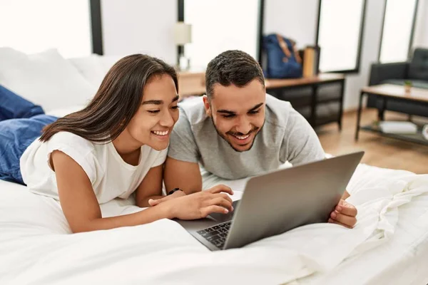 Yatak Odasında Dizüstü Bilgisayar Kullanarak Mutlu Gülümseyen Genç Latin Çift — Stok fotoğraf