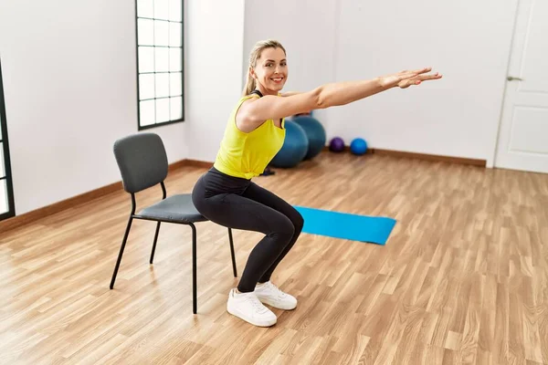 Young blonde girl smiling happy training at sport center.