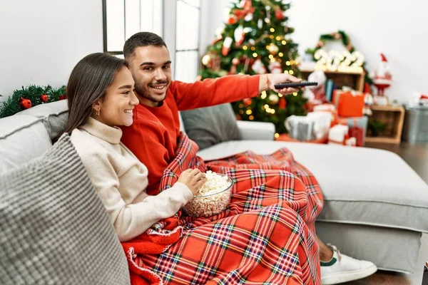 Jovem Casal Hispânico Assistindo Filme Sentado Sofá Pela Árvore Natal — Fotografia de Stock