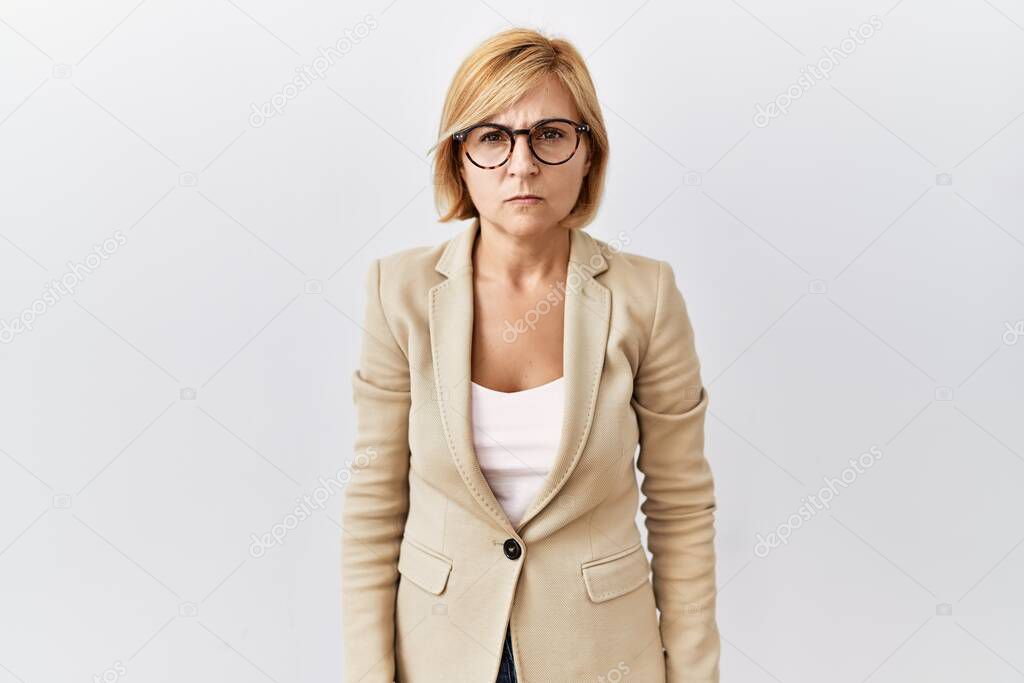 Middle age blonde business woman standing over isolated background skeptic and nervous, frowning upset because of problem. negative person. 