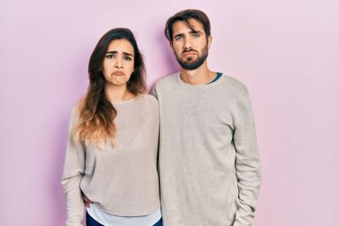 Gündelik giysiler giyen genç İspanyol çift üzgün ve endişeli, kızgın ve korkmuş bir şekilde ağlıyorlar. hüzünlü ifade. 