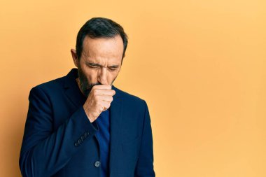 Orta yaşlı İspanyol bir adam iş kıyafetleri giyip kendini kötü hissediyor ve soğuk algınlığı veya bronşitin belirtisi olarak öksürüyor. sağlık hizmeti kavramı. 