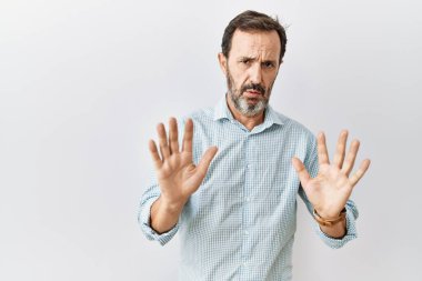 Arka planda sakallı, orta yaşlı İspanyol bir adam. Avuçlarını kaldırıyor, reddediyor ve iğrenç bir ifadeyle reddediyor. Dur ve yasakla. 