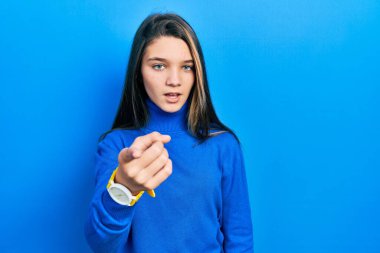 Balıkçı yaka kazak giyen genç esmer kız kameraya karşı kızgın ve sinirli. 