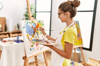 Sanat stüdyosunda kendine güvenen sevimli bir kız.