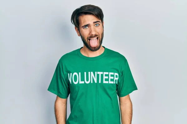 Jovem Hispânico Vestindo Shirt Voluntária Furar Língua Feliz Com Expressão — Fotografia de Stock