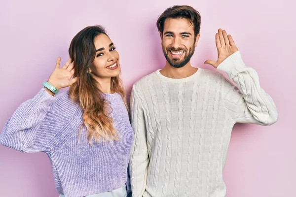 Young Hispanic Couple Wearing Casual Clothes Waiving Saying Hello Happy — ストック写真