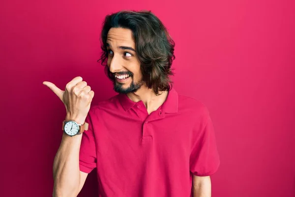 Jovem Hispânico Vestindo Roupas Casuais Apontando Polegar Para Lado Sorrindo — Fotografia de Stock