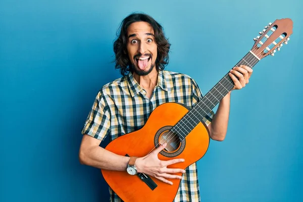 Giovane Uomo Ispanico Suonare Chitarra Classica Attaccare Lingua Fuori Felice — Foto Stock