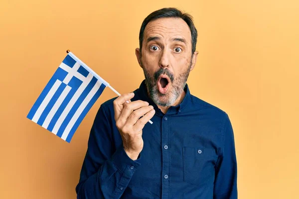 Hispanischer Mann Mittleren Alters Mit Griechischer Flagge Erschrocken Und Erstaunt — Stockfoto