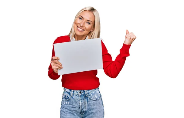 Mujer Rubia Joven Sosteniendo Banner Vacío Blanco Gritando Orgulloso Celebrando —  Fotos de Stock