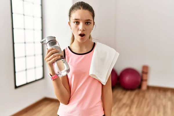 Junge Brünette Teenager Tragen Sportbekleidung Halten Wasserflasche Schockgesicht Schauen Skeptisch — Stockfoto