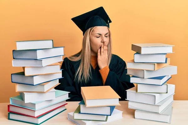 Young Caucasian Woman Wearing Graduation Ceremony Robe Sitting Table Bored — ストック写真