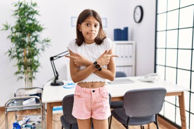 Pediyatri kliniğinde dikilen genç İspanyol kız her iki tarafı da farklı yönlerle işaret ediyor. 