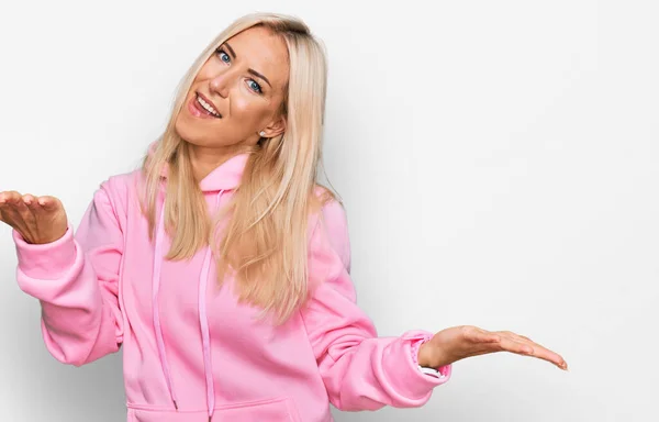 Ung Blond Kvinna Bär Casual Sweatshirt Leende Glad Erbjuder Händerna — Stockfoto