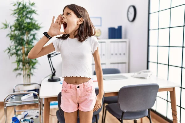 Genç İspanyol kız pediatri kliniğinde el ve ağızla bağırıyor ve bağırıyordu. iletişim konsepti. 