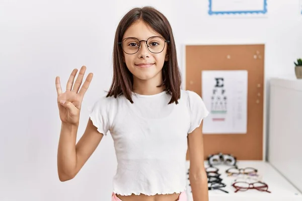 Young Hispanic Girl Wearing Glasses Showing Pointing Fingers Number Four — Stockfoto