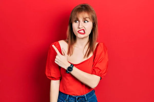 Roodharige Jonge Vrouw Draagt Casual Rood Shirt Wijzen Opzij Bezorgd — Stockfoto