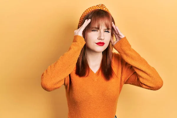 스트레스때문에 머리에 통증을 느끼기 머리에 오렌지색 스웨터를 머리의 편두통으로 고생하다 — 스톡 사진