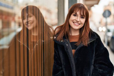 Sokakta kendinden emin gülümseyen genç bir kadın