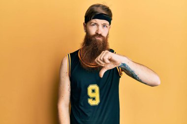 Uzun sakallı, basketbol forması giyen, mutsuz, kızgın, reddedilmiş ve olumsuz jestli kızıl saçlı bir adam. kötü ifade. 