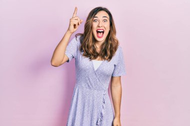 Gündelik kıyafetler giyen genç İspanyol kız başarılı bir fikri işaret ediyor. Heyecanlı ve mutlu. Bir numara.. 