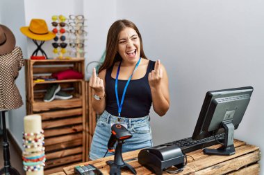Young brunette woman holding banner with open text at retail shop showing middle finger doing fuck you bad expression, provocation and rude attitude. screaming excited 