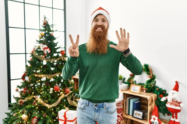 Rotschopf Mit Langem Bart Trägt Weihnachtsmütze Weihnachtsbaum Und Zeigt Mit — Stockfoto