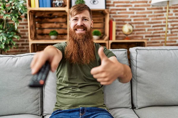 Redhead Man Long Beard Holding Television Remote Control Smiling Happy — Foto Stock
