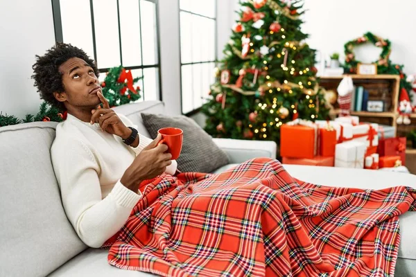 Joven Afroamericano Sentado Sofá Bebiendo Café Por Árbol Navidad Pensando — Foto de Stock